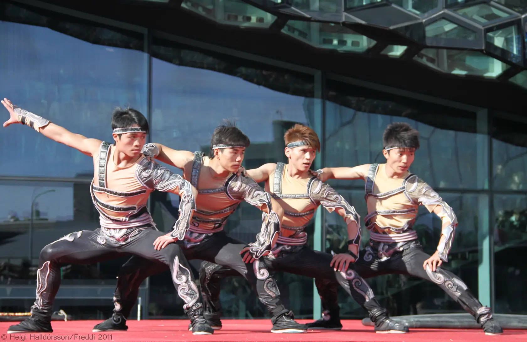 Performers from a Chinese acrobatics troupe in a dynamic act on a brightly lit stage